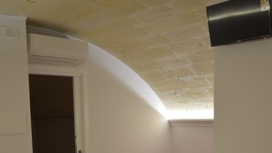 A compact room with a bed, a bench, and towels on the floor. - In & Out Matera (Matera)