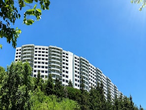 A multi-story hotel with balconies, surrounded by greenery.
