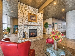 A lobby with a stone fireplace, leather seating, and a floral arrangement.