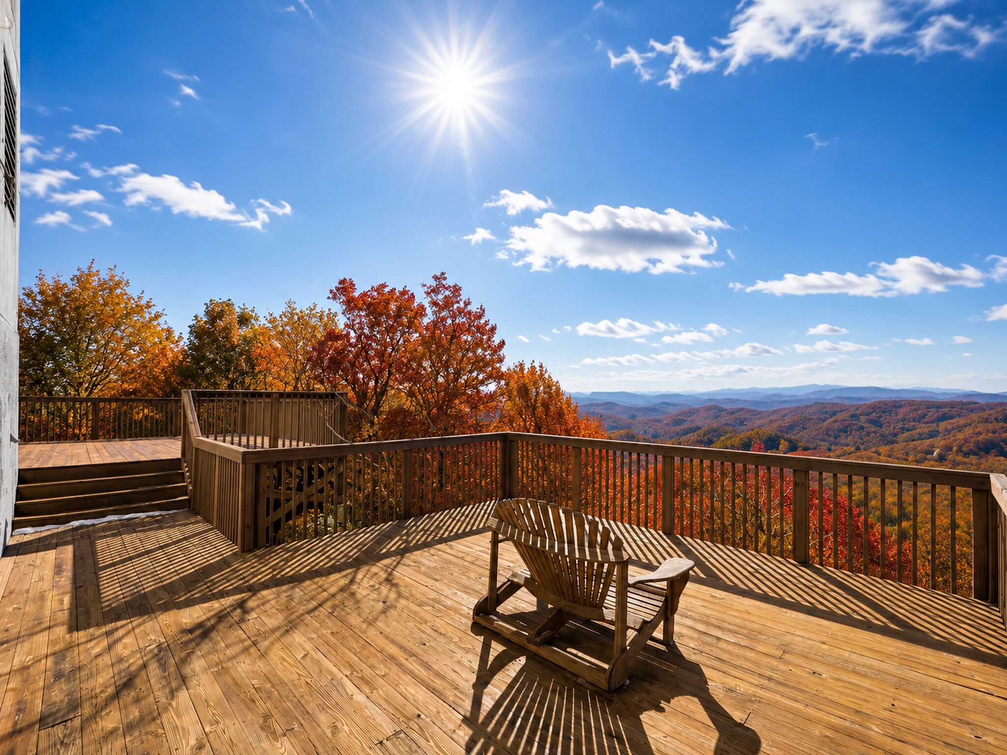 A wooden deck with a view of autumn foliage and distant mountains.