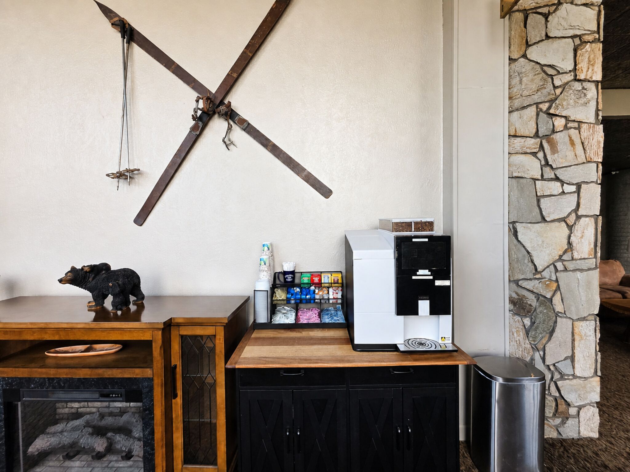 A wooden table with a bear figurine, a coffee machine, and a snack dispenser.