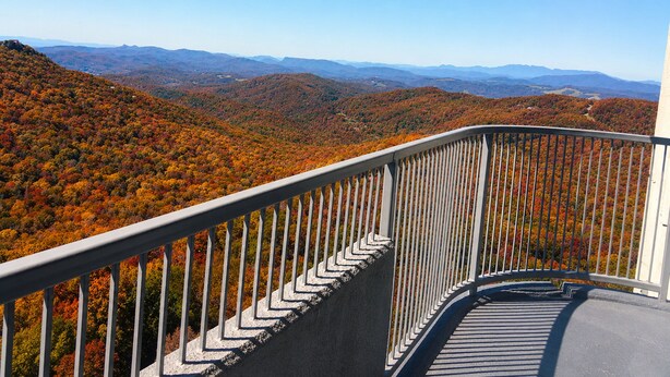 A balcony with a metal railing overlooking a mountainous landscape with autumn foliage. - Sugartop Resort 6th-Floor Corner Condo: Breathtaking Mountain Views - 2BR (Sugar Mountain)