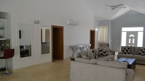 A spacious living room with a large sofa set, a red chair, and a ceiling fan. - THIS IS IT!!!!!! Newly built Renters Paradise (Sosua)