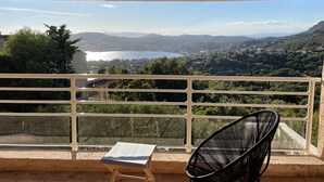 Un balcon avec vue sur un lac et des montagnes.