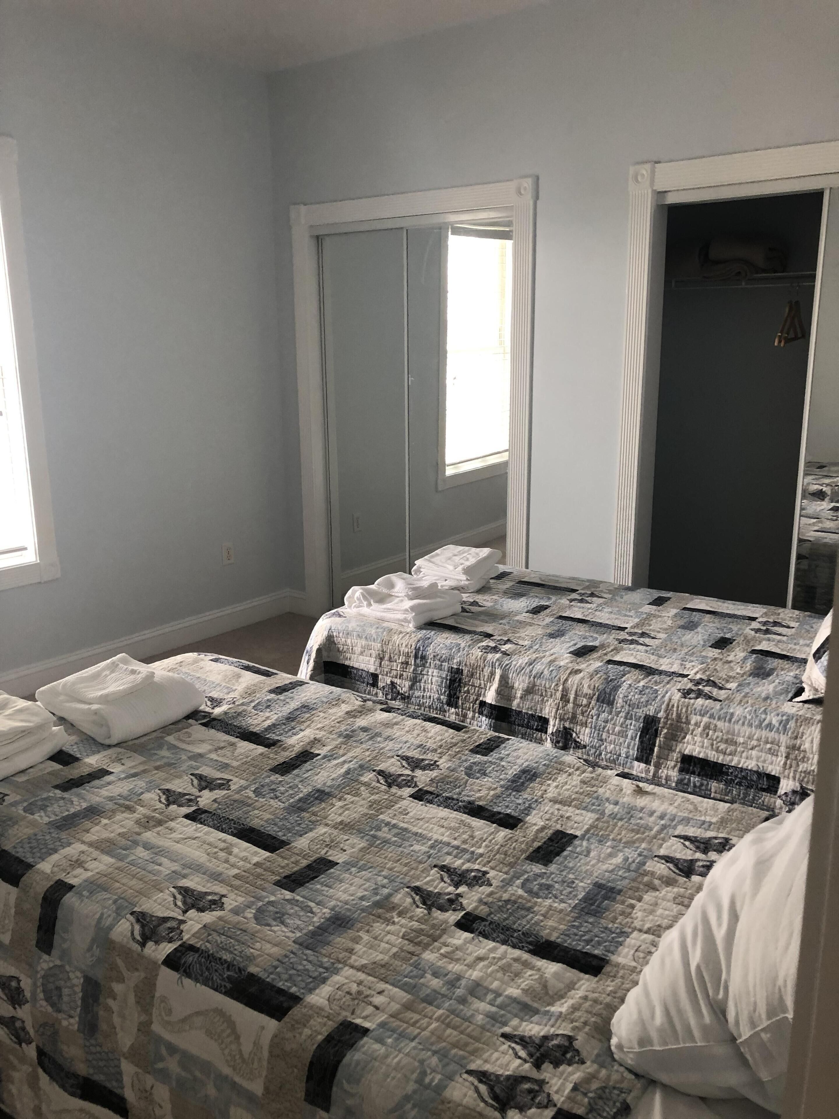 Un dormitorio con cama, armario y ventana.