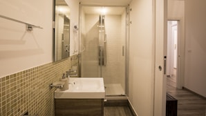 A modern bathroom with a large sink, a glass shower enclosure, and a mirror above the sink. - Sammartino suite (Palermo)