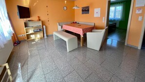 A room with a dining table, bench, and a television on the wall. - Non-smoking vacation apartment 50sqm, no. 1, 2 bedrooms, max. 4 persons - (Rust)