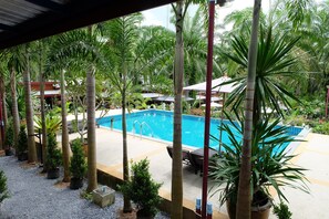 A pool area with palm trees, lounge chairs, and umbrellas. - Palmthien Pool Villa Aonang (Krabi)