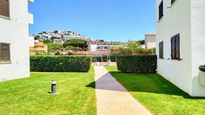 A pathway leading to a building with a view of a hilltop area.