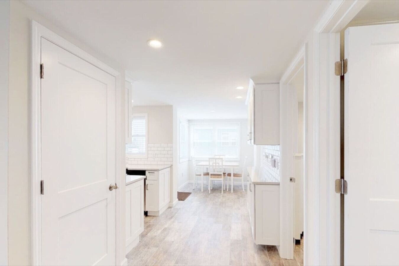 A bright, white interior with a kitchen and dining area.