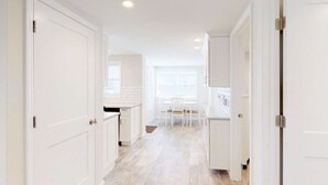 A bright, white interior with a kitchen and dining area. - Stylish space, 180ft to beach,parking (Point Pleasant Beach)