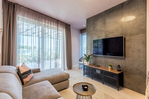 Relax in this stylish living room with a large flat-screen TV, comfortable sofa, and a cozy coffee table.