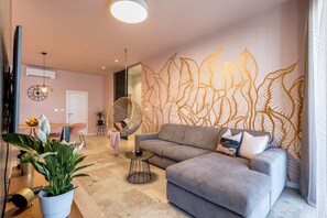Relax in this inviting living room with a comfortable sofa, round coffee table, and lush greenery.