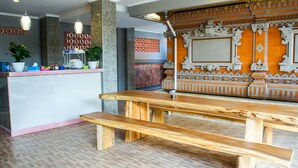 A wooden bench and a counter with dishes and a potted plant. - Dana Homestay (Tibubeneng)