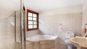 A bathroom with a shower, bathtub, toilet, and sink.