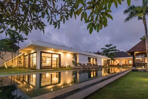 A modern villa with a swimming pool, large windows, and a well-lit outdoor area. - Seminyak, Large Groups, 11 Bdr/14 beds,Near Beach (Seminyak)