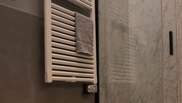 A modern bathroom with a bidet, a sink, and a towel rack. - Domus Alberico (Rome)