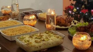 A dining table with various dishes, candles, and a Christmas tree. - Pousada Solar da Lagoa Baixio (Esplanada)