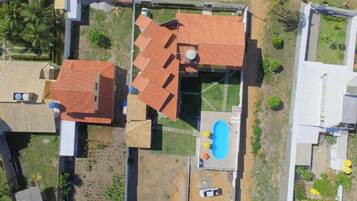 An aerial view of a residential property with multiple buildings, a swimming pool, and a garden area.