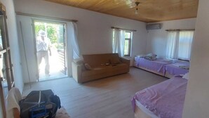 Una habitación con sofá, cama y ventana.