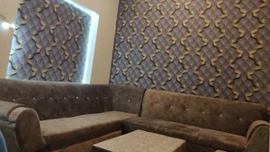 Ein modernes Wohnzimmer mit einem Ecksofa, einem Couchtisch und dekorativen Wandverkleidungen.