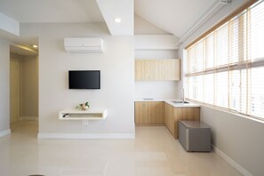 A modern kitchen with a built-in oven, a sink, and wooden cabinets. - Sunshine Boutique Hotel Phu My Hung (Ho Chi Minh City)