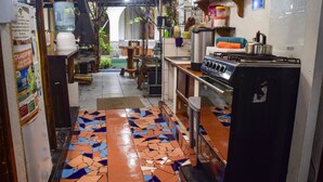 Una cocina con piso de baldosas, estufa y varios electrodomésticos.