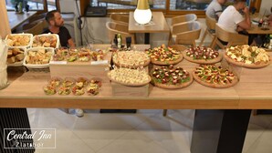 A buffet table with various food items and a sign indicating the Central Inn Zlatabor. - Central Inn (Zlatibor)