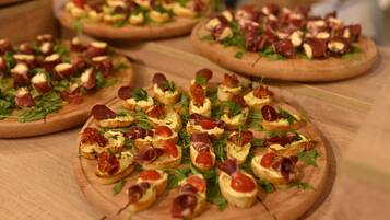 Ein Holztisch mit mehreren runden Holzbrettern, die mit verschiedenen Speisen wie Brot, Käse und Garnituren belegt sind.