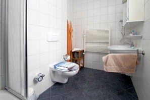 A bathroom with a toilet, a sink, a towel rack, and a shower area. - (278) 2-room apartment - apartment complex Yachthafenresidenz (Kühlungsborn)
