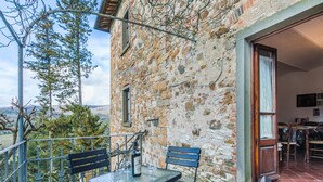 A stone building with a balcony, outdoor seating, and a view of the countryside. - La Terrazza by Interhome (Radda in Chianti)
