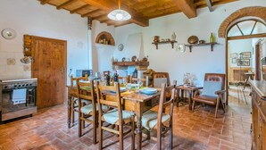 A rustic kitchen with wooden furniture, a tiled floor, and a brick oven. - La Terrazza by Interhome (Radda in Chianti)