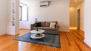 A modern living room with a sofa, a coffee table, and a rug.