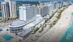 A coastal hotel with multiple high-rise buildings, a beach, and a pool area. - BEACHFRONT ONE BEDROOM 2 BATH CONDO-HOTEL WITH PARKING ON THE BEACH (Miami)