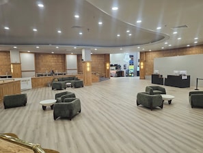 A spacious lobby with a curved ceiling, wooden panel walls, and a seating area with sofas and tables. - BEACHFRONT ONE BEDROOM 2 BATH CONDO-HOTEL WITH PARKING ON THE BEACH (Miami)