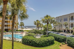 A hotel with a pool, palm trees, and a view of the beach. - Enjoy Full Resort Access and Ocean Views at KP247! (Saint Simons Island)