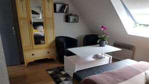 Ein Schlafzimmer mit Bett, Schreibtisch, Stuhl, Kleiderschrank und einem Topfpflanzen.