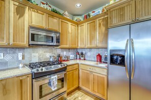 A kitchen with wooden cabinets, stainless steel appliances, and a granite countertop. - Family-friendly home w/full kitchen, gas grill & patio - close to downtown (Sequim)