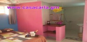 Cozy retreat with a statement pink accent wall, a comfortable bed, and a convenient workspace.