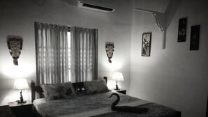 Een slaapkamer met een bed, twee bedlampjes, een zwaan decoratie, een raam met gordijnen en wandlampen.