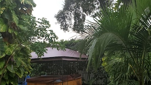 A wooden hot tub surrounded by lush greenery and a stone pathway. - Beautiful luxury 2 bedroom private   Cottage (Dunedin)
