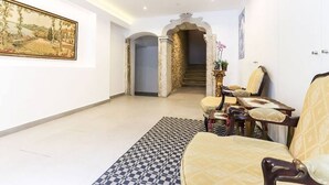 Un vaste espace de vie comprenant un canapé, un tapis à motifs et un tableau accroché au mur.