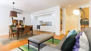 Un appartement moderne comprenant un coin repas, une kitchenette et un salon.