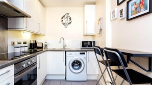 A compact kitchen with a washing machine, a microwave, and a sink.