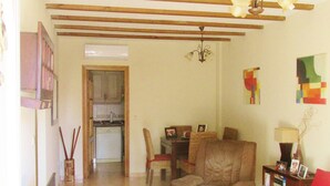 A living room with a sofa, a dining table, and a kitchen in the background. - bungalow with terrace (Gran Alacant)