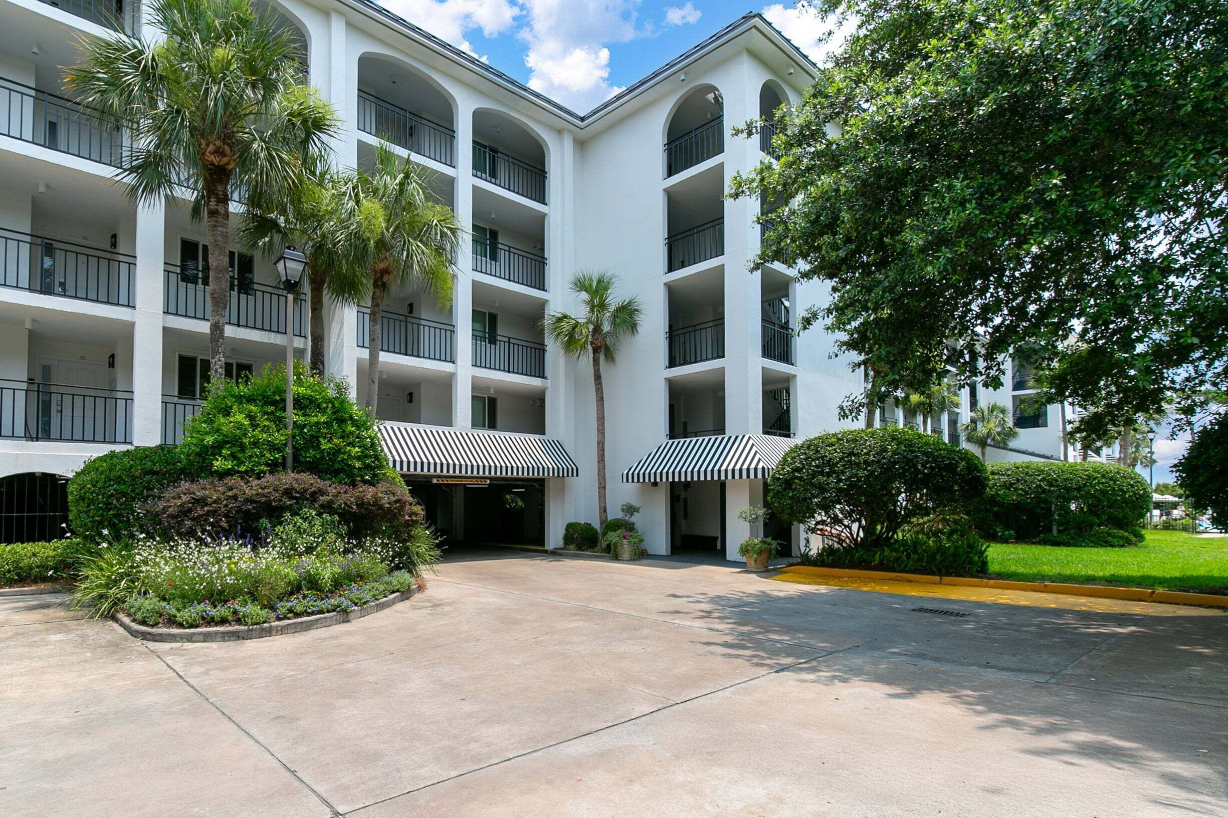 A multi-story hotel with balconies, a central courtyard, and surrounding greenery.