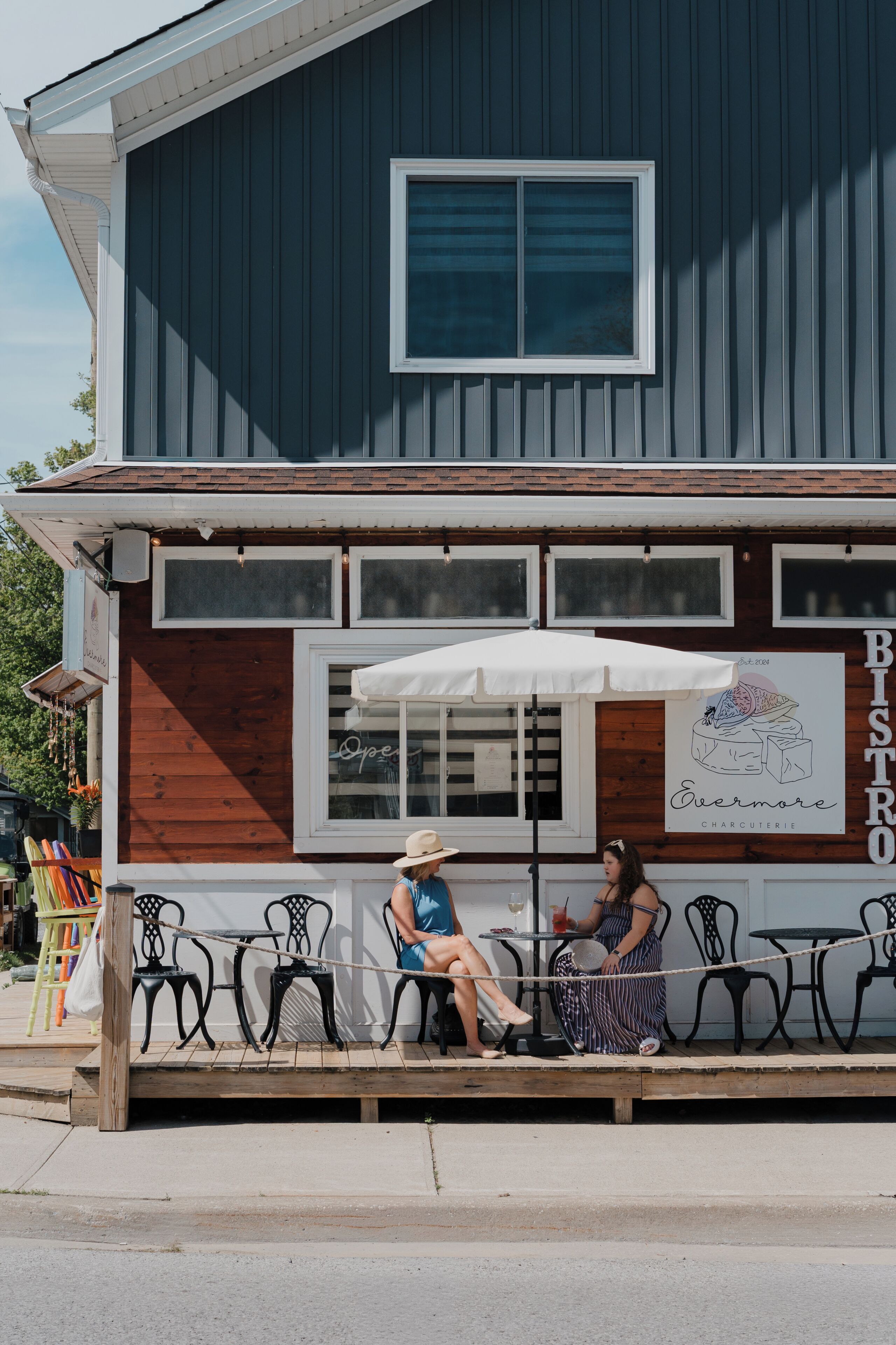 A restaurant with outdoor seating, a wooden facade, and a sign indicating it is a bistro.