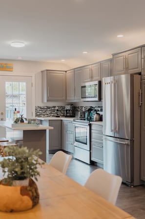 A modern kitchen with stainless steel appliances, a microwave, and a refrigerator.