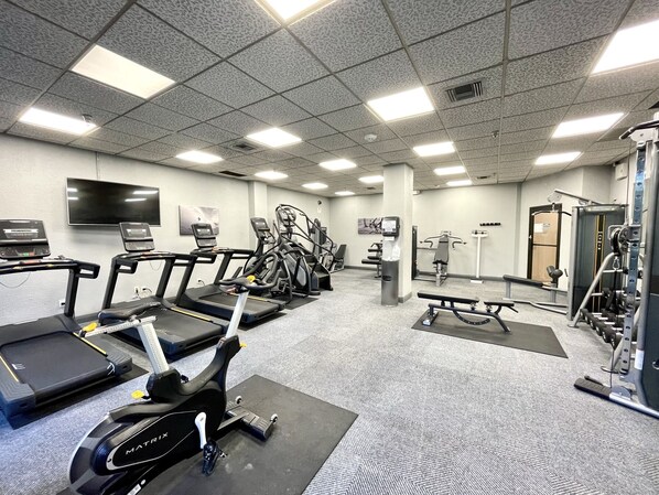 A gym with treadmills, elliptical machines, and weight equipment.