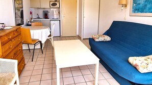 A compact living space with a kitchenette, a dining area, and a sofa. - Air-conditioned studio with parking in Banyuls-sur-Mer near the sea (Banyuls-sur-Mer)
